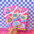 Pink packaging with colorful text and graphics on a checkered background