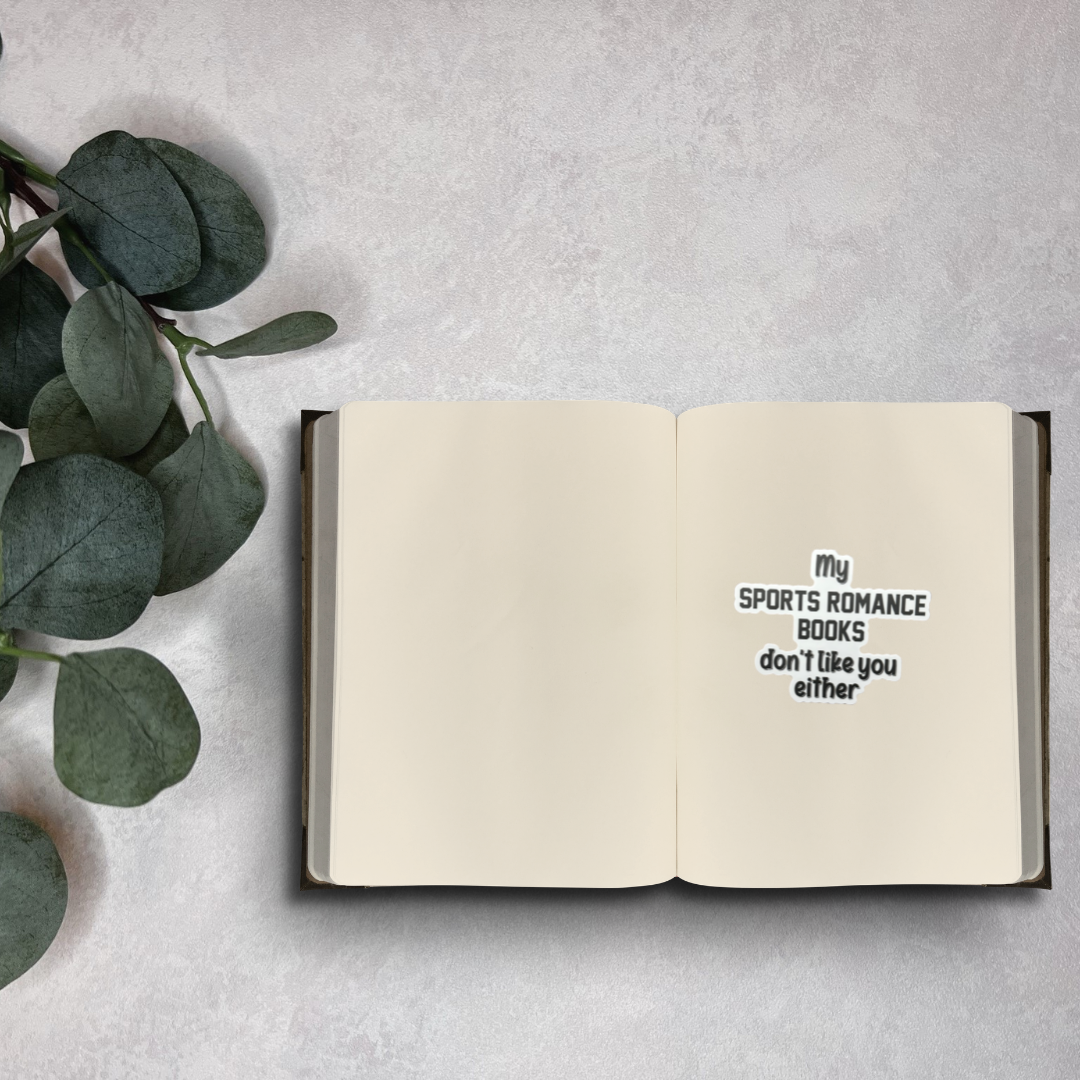Open notebook with text on a gray surface with green leaves