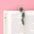 Floral bookmark on an open book with a pink background