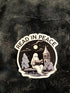 A die-cut sticker featuring a spooky night scene with a ghost reading on a bench under a full moon, with the words &