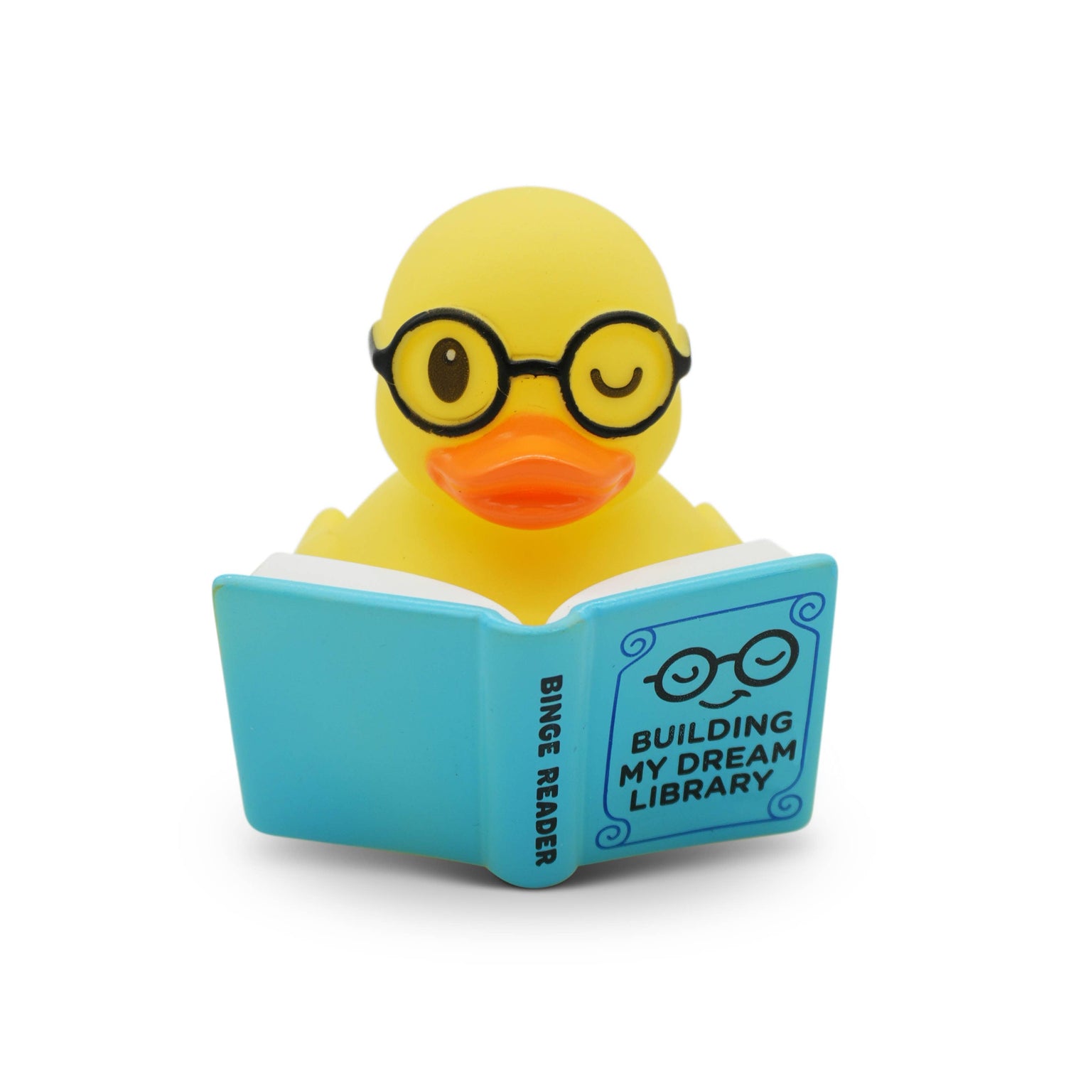 Yellow rubber duck wearing glasses and reading a book titled &