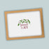 A white background with a brown frame containing a decorative wreath and the text "Peace & Joy" in a cursive font.