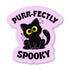 A die-cut sticker featuring a black cartoon cat with large yellow eyes on a light pink background, with the words &