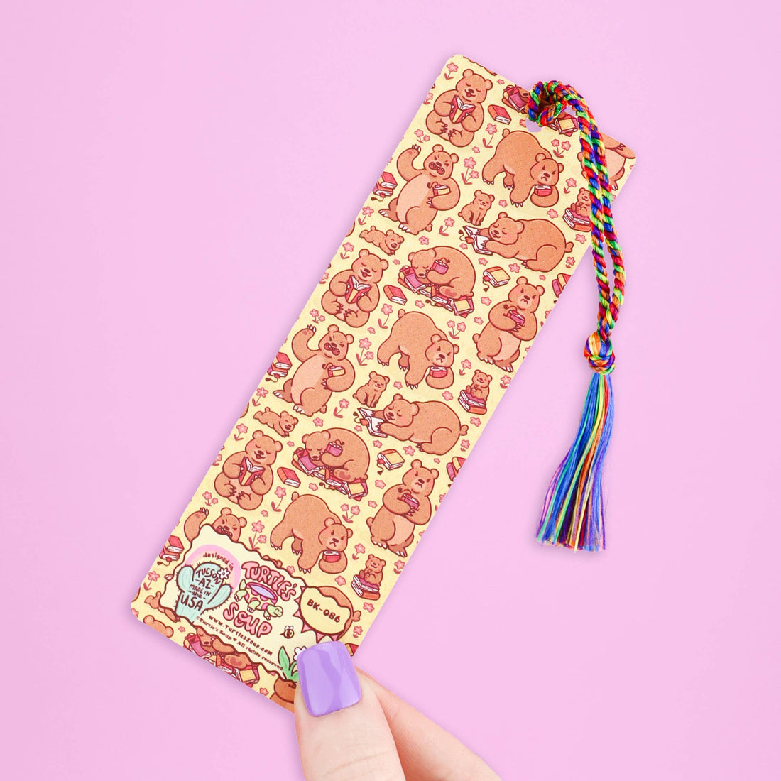 Bookmark with bear pattern and colorful tassel on a pink background