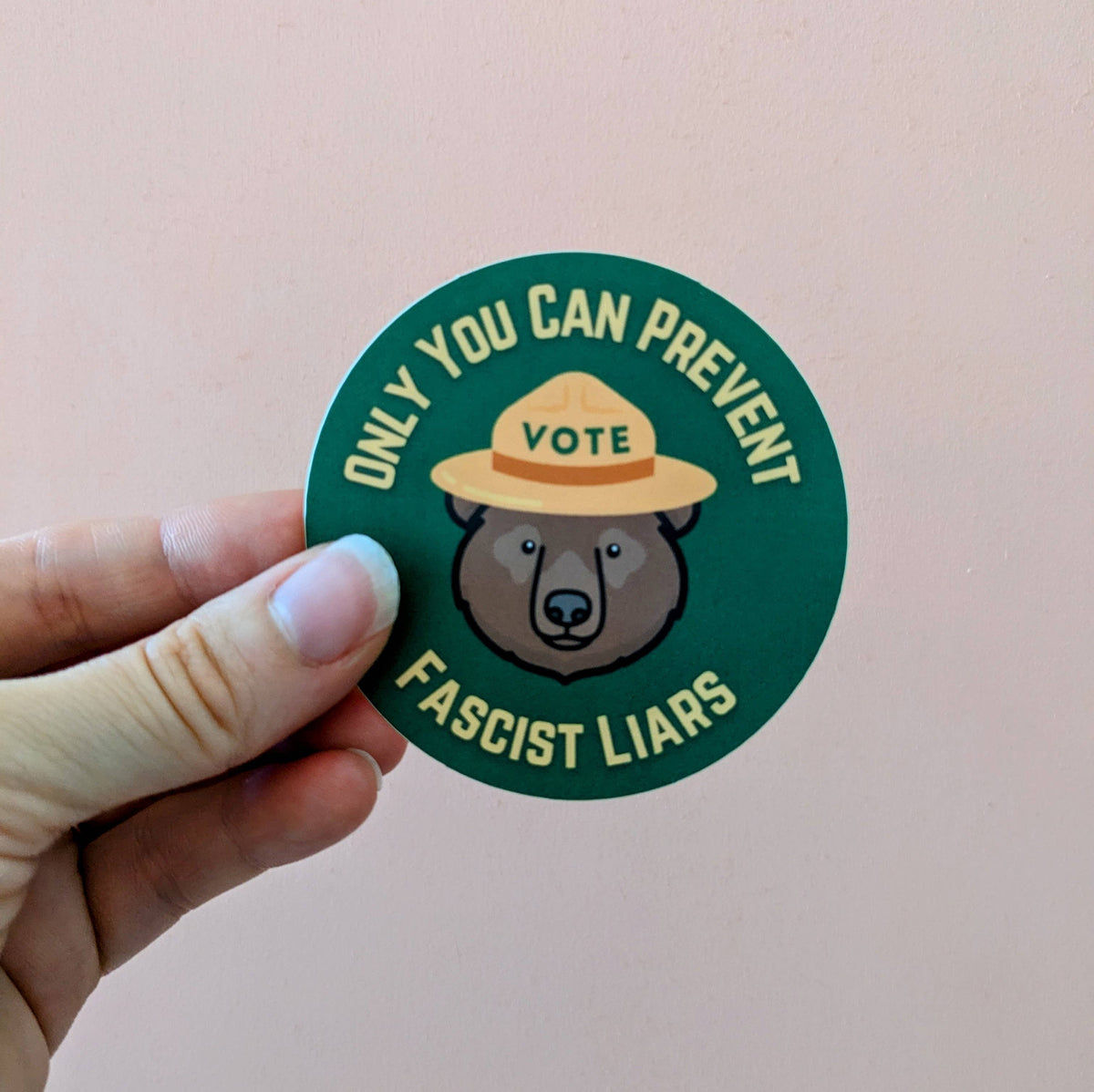 Sticker with bear wearing a hat and text on a pink background
