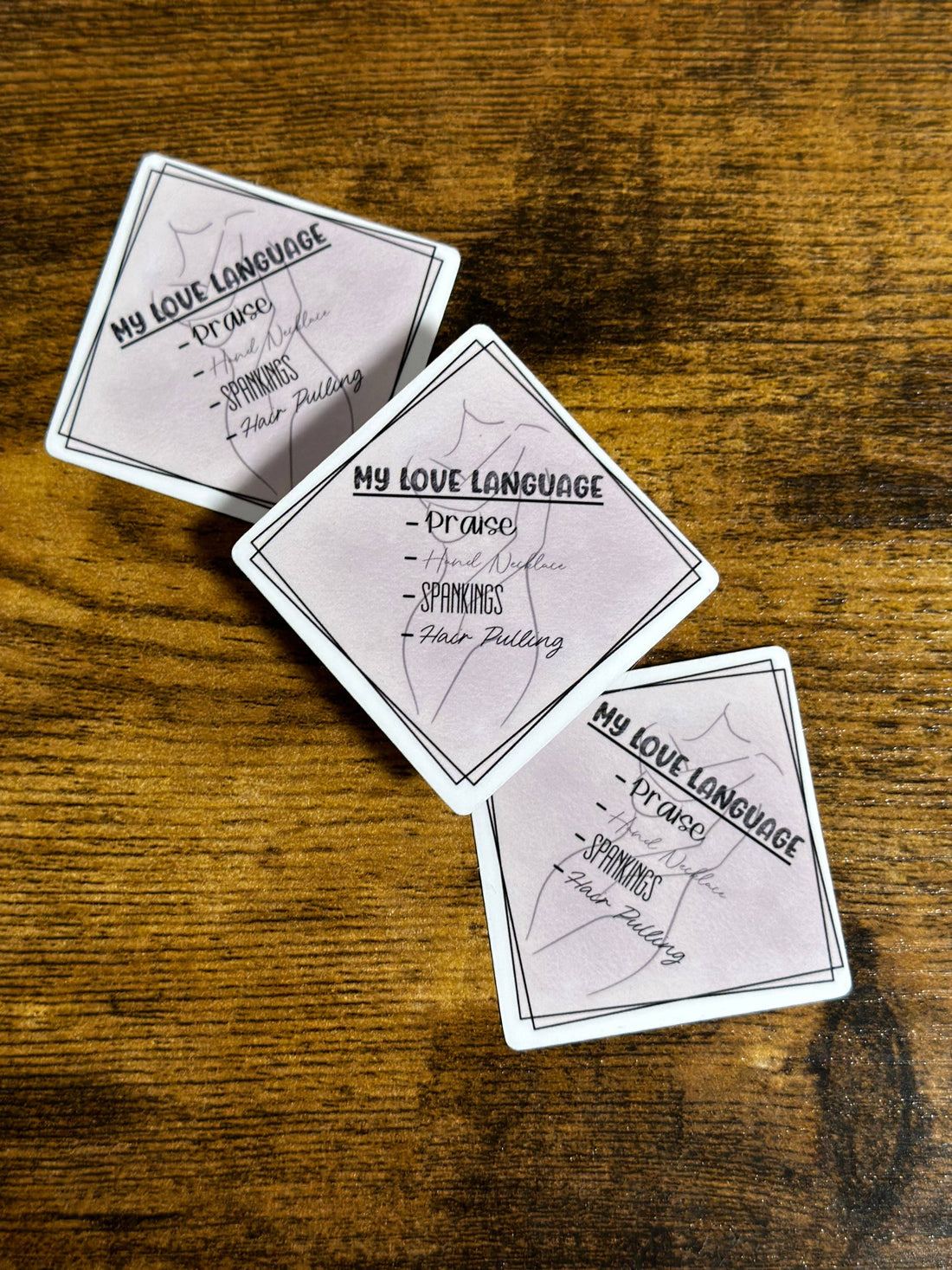 Three playing cards with text on a wooden surface