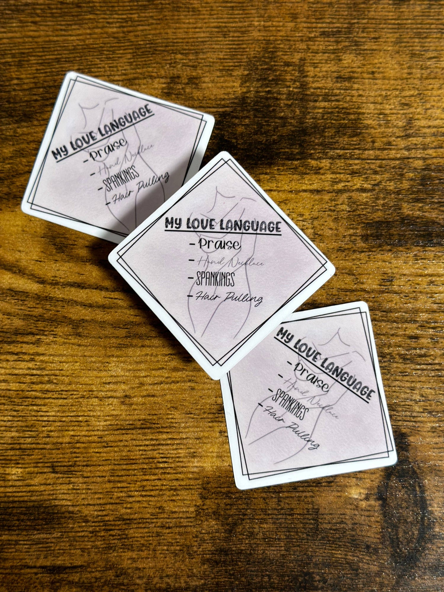 Three playing cards with text on a wooden surface