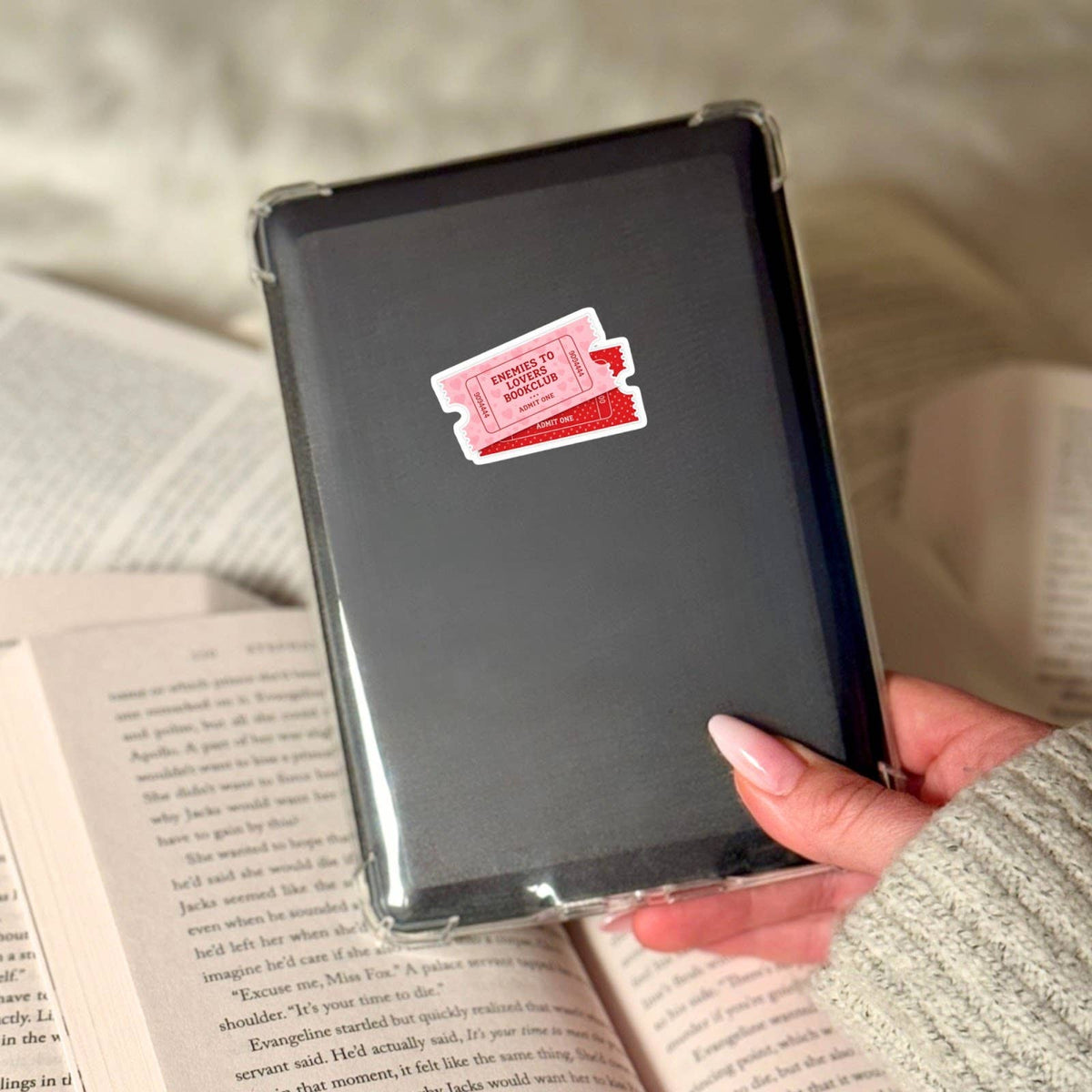 Black notebook with a red and white sticker held over an open book