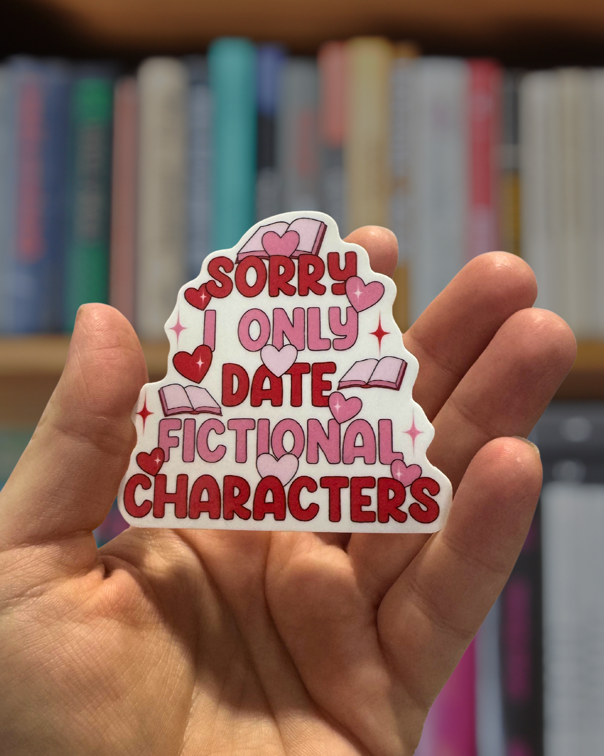 Hand holding a sticker with text &