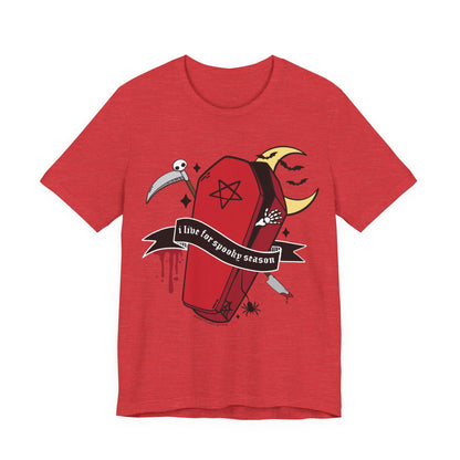 A red heather short-sleeve t-shirt with a gothic-themed graphic print of a coffin, a scythe, a spider, a crescent moon, and a banner that reads &