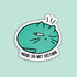 A die-cut sticker featuring a teal cartoon cat with one eye closed and the text &