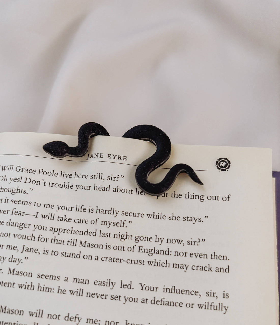 Black mustache-shaped hair clip on a page of &