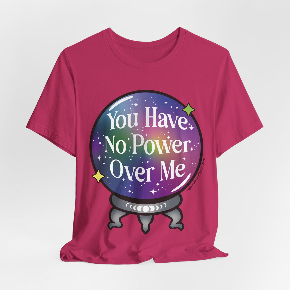 A bright pink short-sleeve t-shirt with a graphic of a crystal ball containing a purple and blue galaxy pattern with the text &