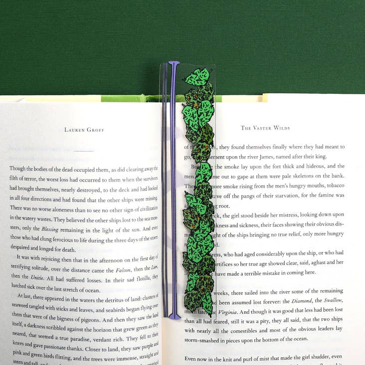 Green leaf-patterned bookmark on an open book with a green background