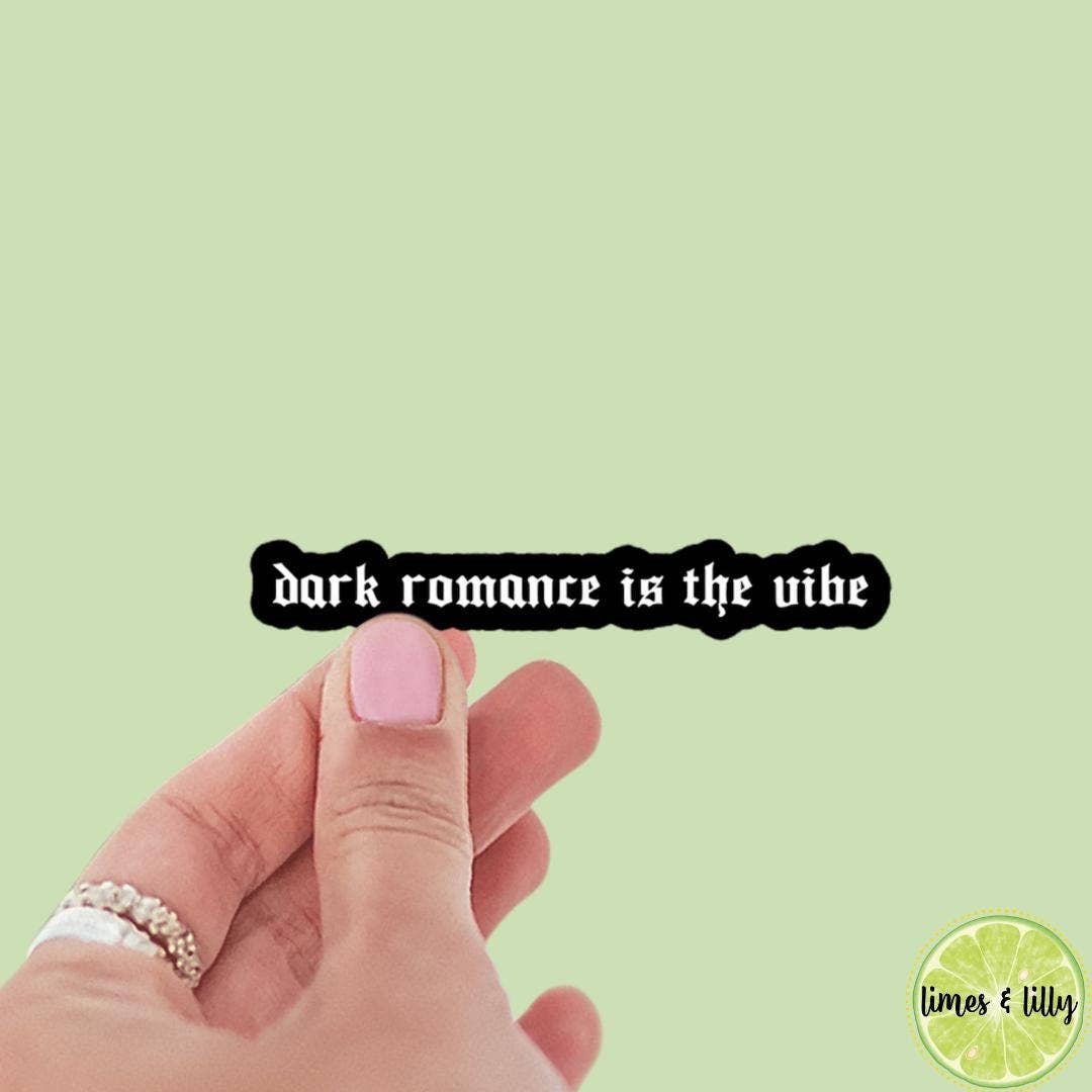 Hand with pink nail polish holding a black sign with &