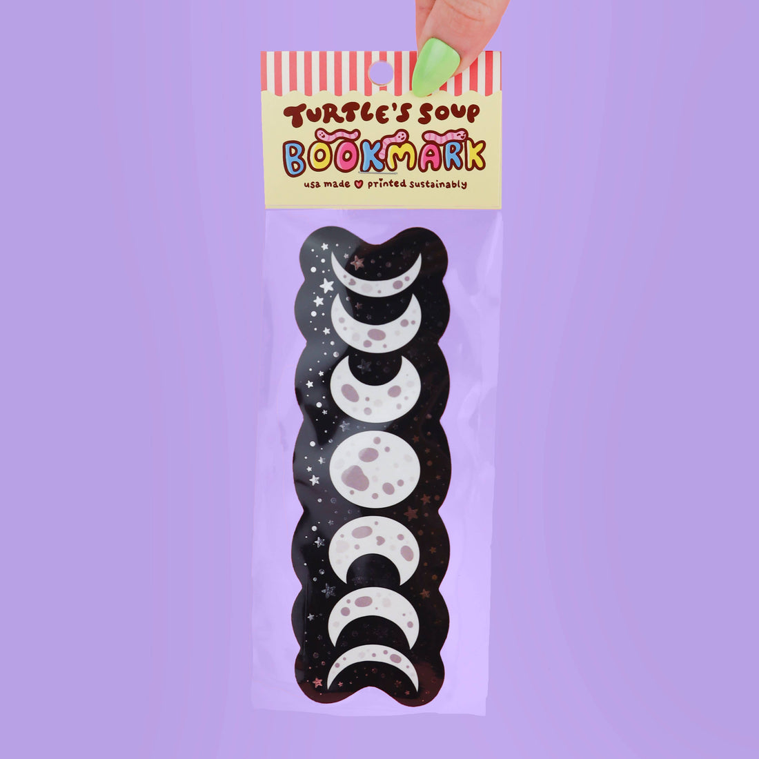 Packaged bookmark with moon phases design on a purple background