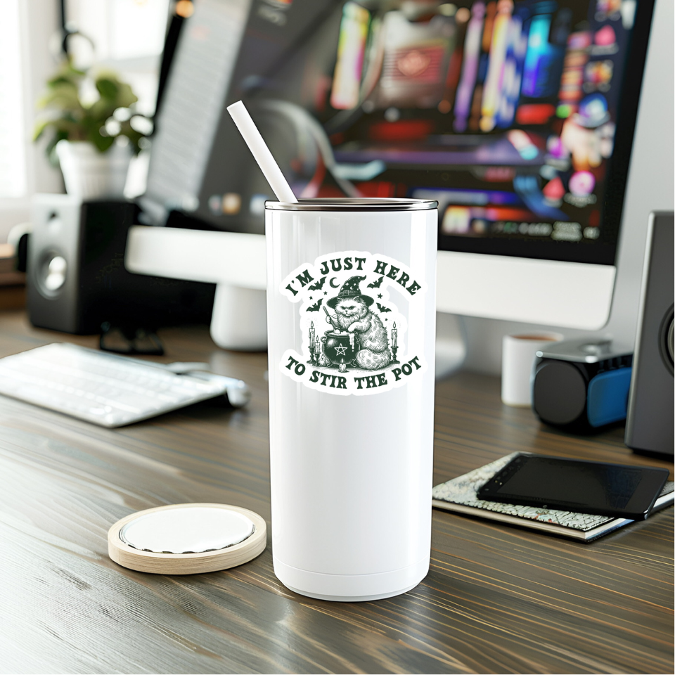 White tumbler with a humorous design on a desk with a computer in the background