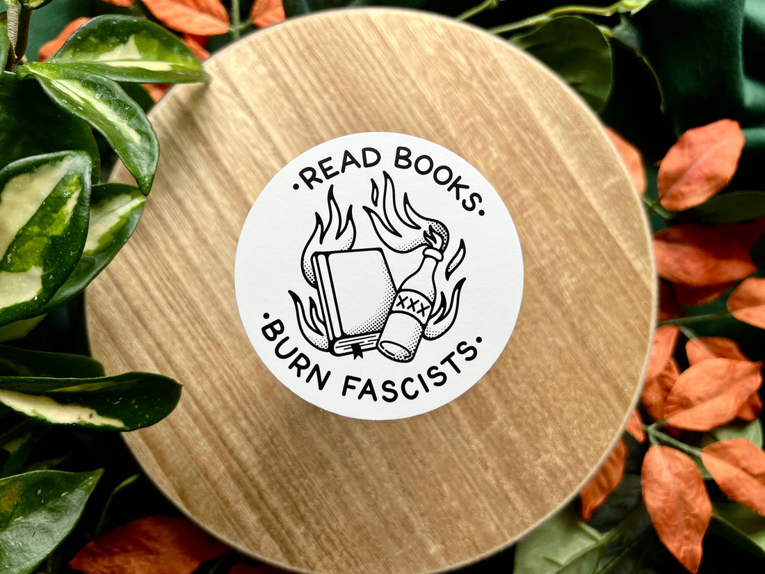 Round wooden coaster with a sticker reading &