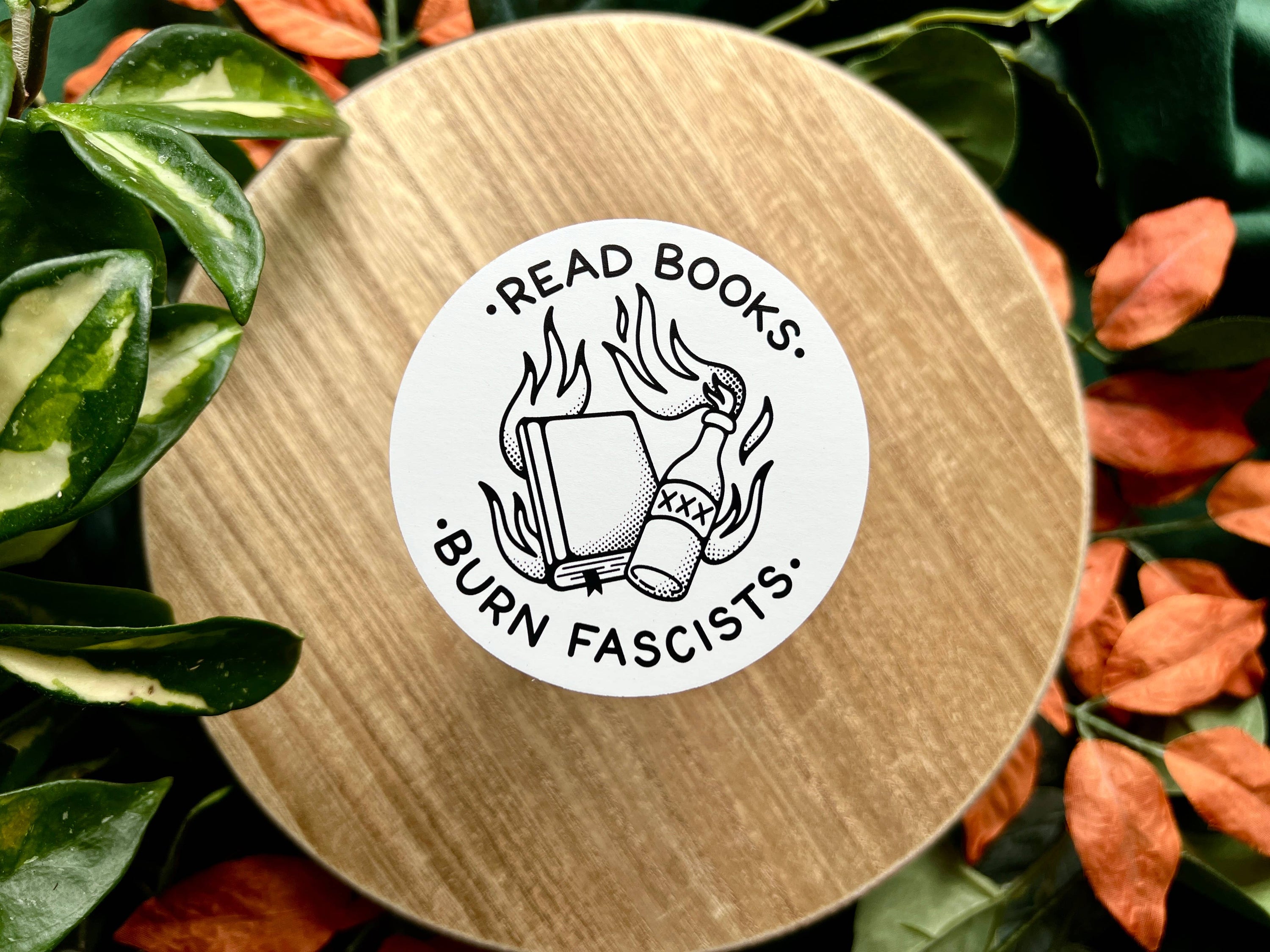 Round wooden coaster with a sticker reading &