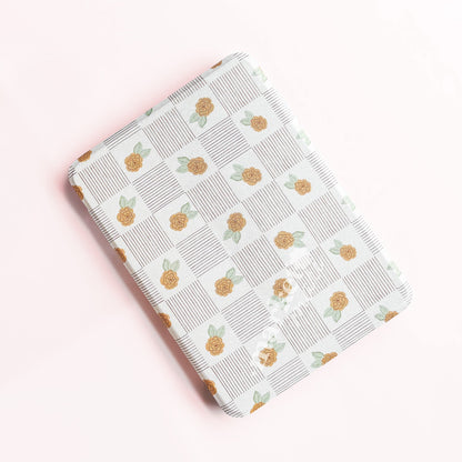a square-shaped object with a repeating pattern of orange flowers and green leaves on a white background.