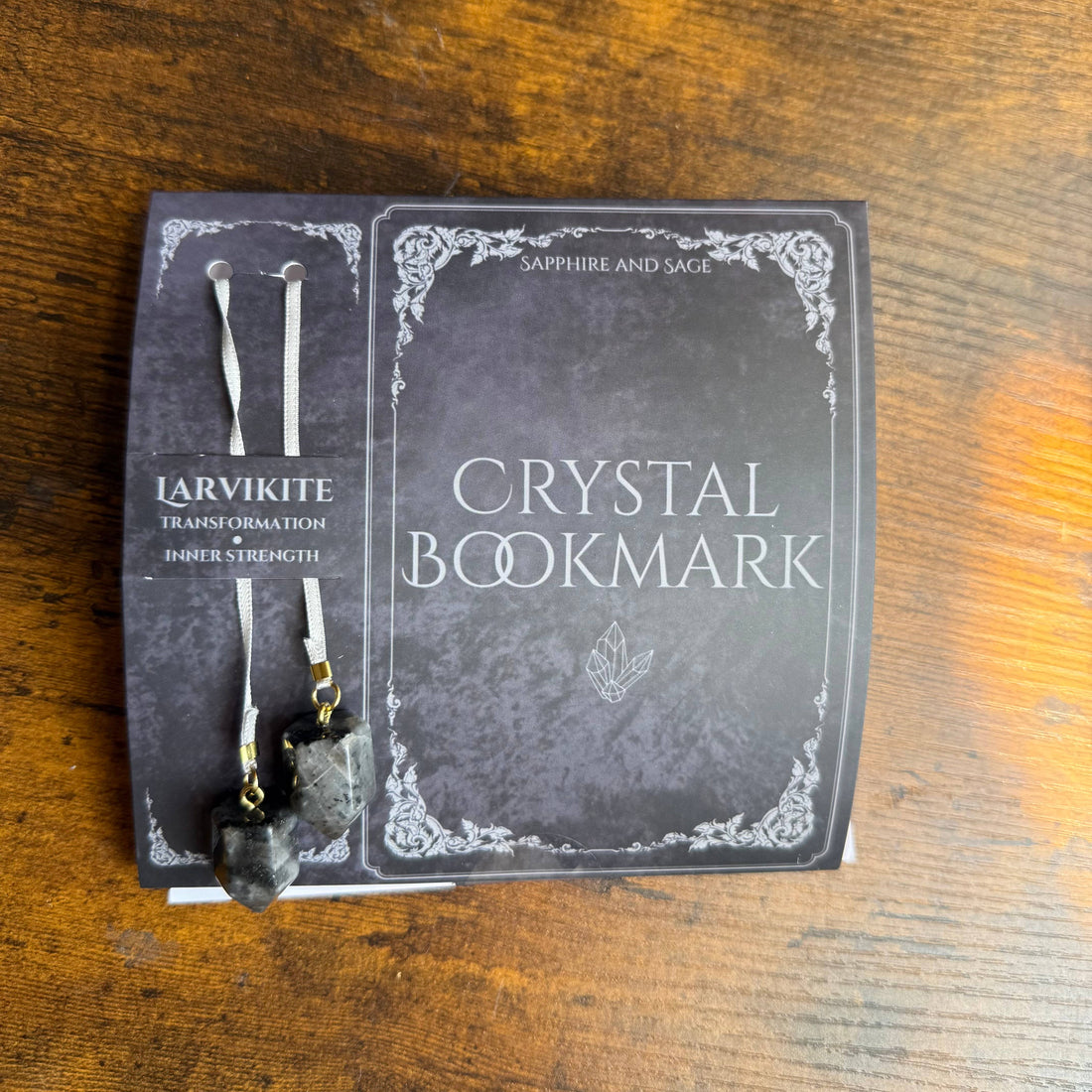 Crystal bookmark with packaging on a wooden surface