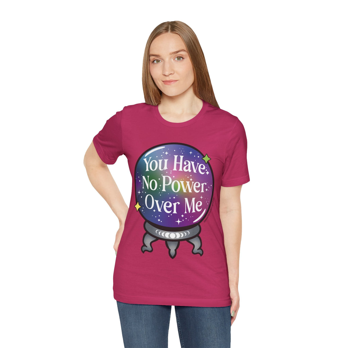 A woman modeling a magenta short-sleeve t-shirt with a colorful graphic of a crystal ball containing stars and the text &