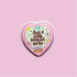 A heart-shaped sticker with a pink background and various colorful illustrations, including flowers, stars, and a smiling face.