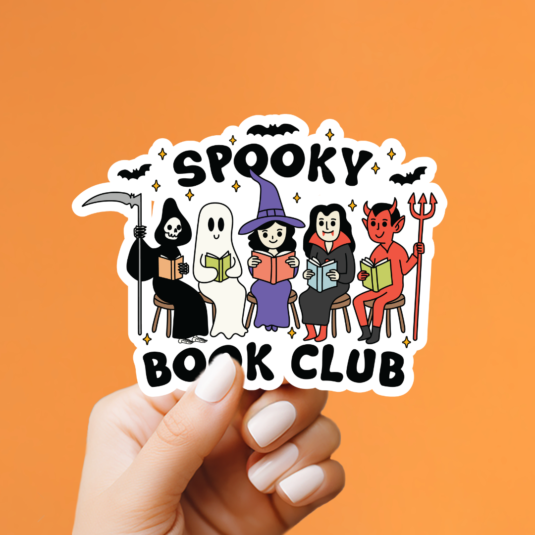 A hand with white manicured nails holds a die-cut sticker featuring cartoon characters from a book club: a grim reaper, ghost, witch, vampire, and devil, with the words &