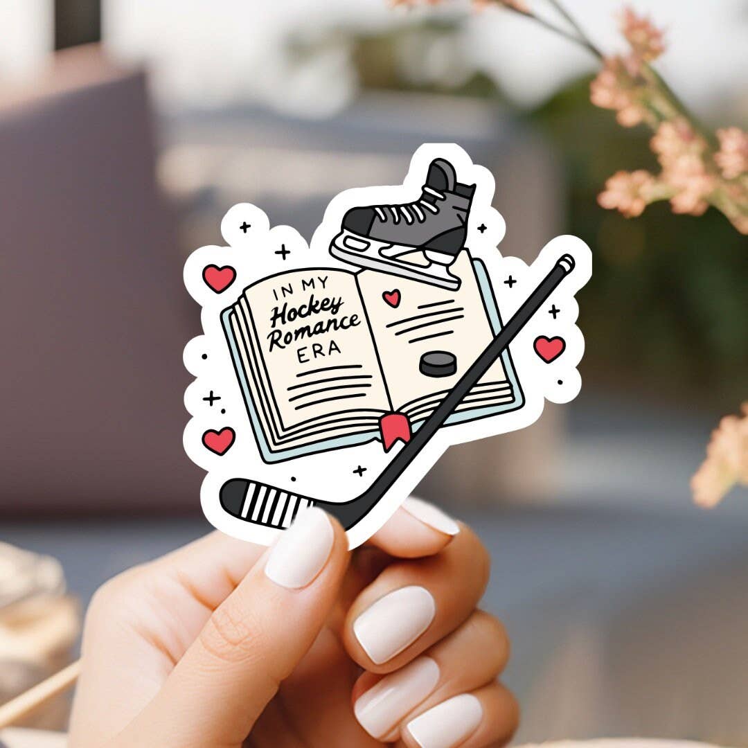 Hand holding a sticker with a book and hockey elements, text &