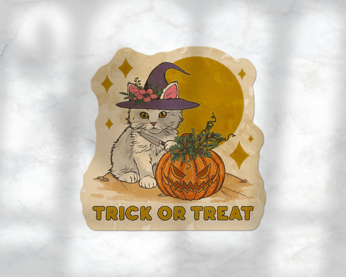 A die-cut sticker featuring a cute white kitten in a witch hat next to a carved orange pumpkin, with the words &