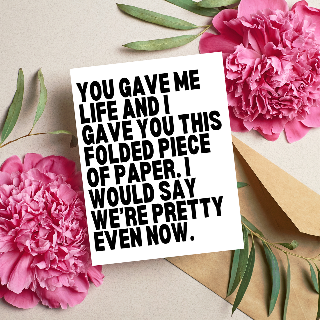 Card with humorous text surrounded by pink flowers and green leaves on a light background
