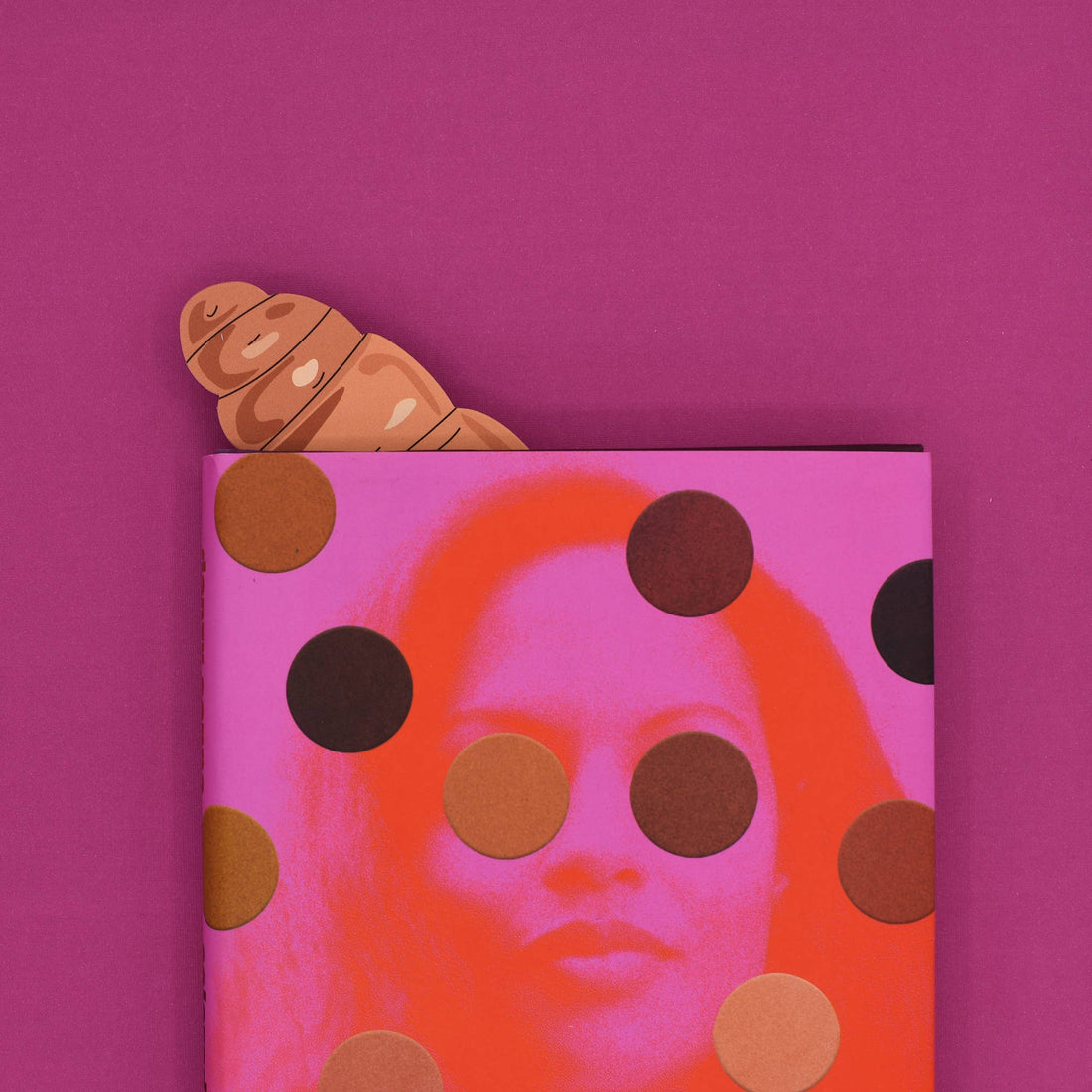 Notebook with polka dot design and a croissant on a pink background