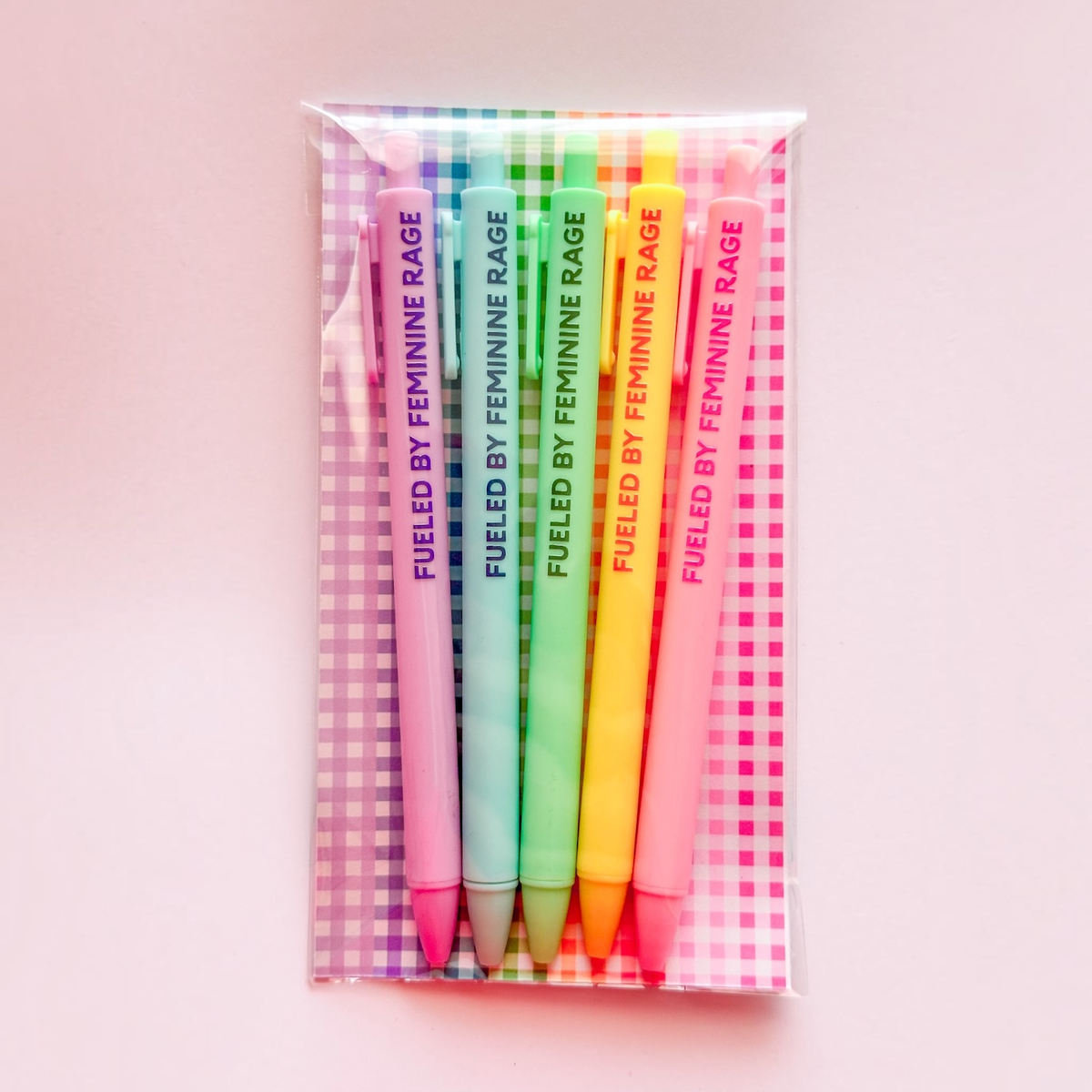 A set of six colorful gel pens in a clear plastic sleeve with a pink and white gingham patterned backing. The pens are labeled &