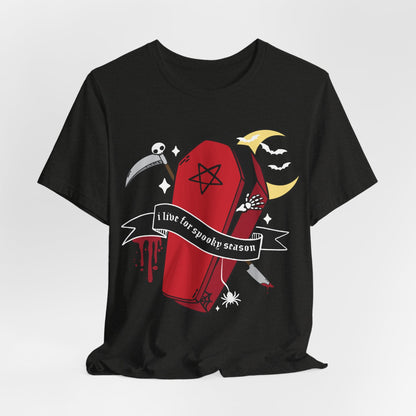 A black short-sleeve t-shirt with a gothic-themed graphic print featuring a red coffin, a scythe, a crescent moon, bats, and a banner that reads &