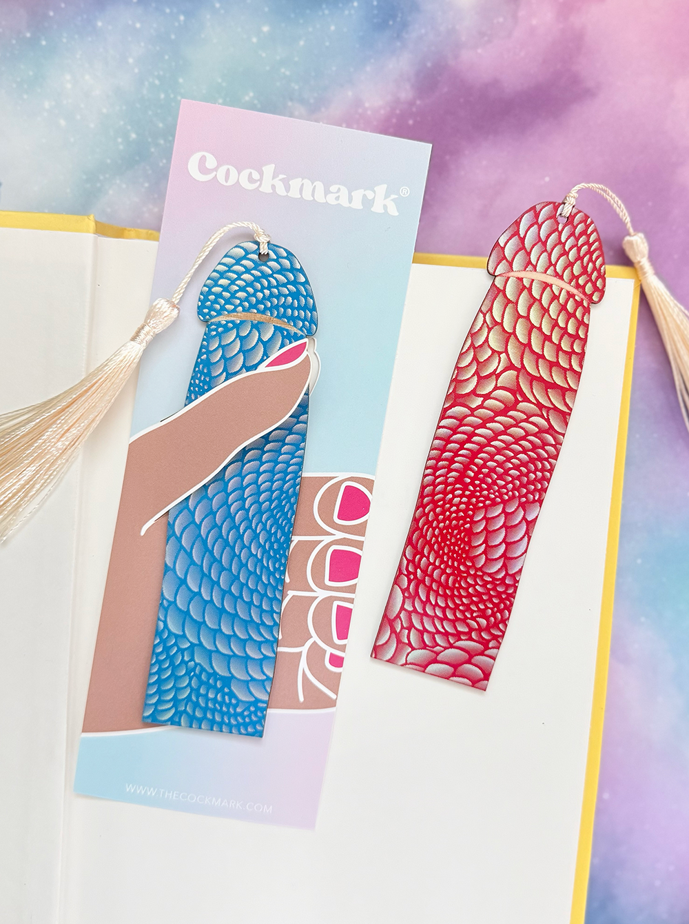 Two colorful mermaid tail bookmarks with tassels on a gradient background.