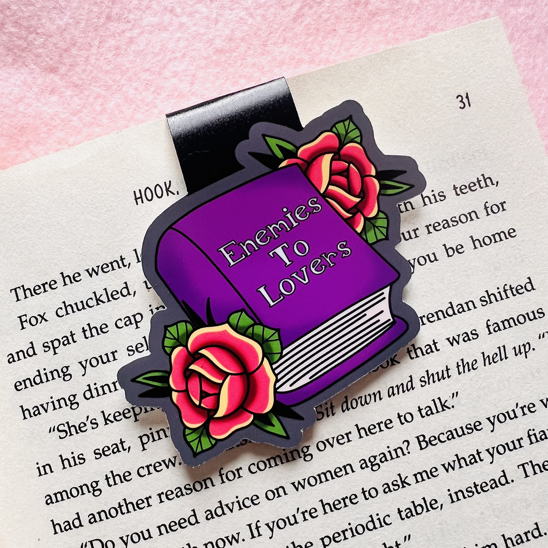 Book-shaped enamel pin with roses on a book page background