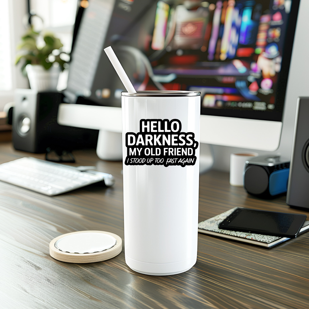 White tumbler with humorous text on a desk with computer equipment in the background