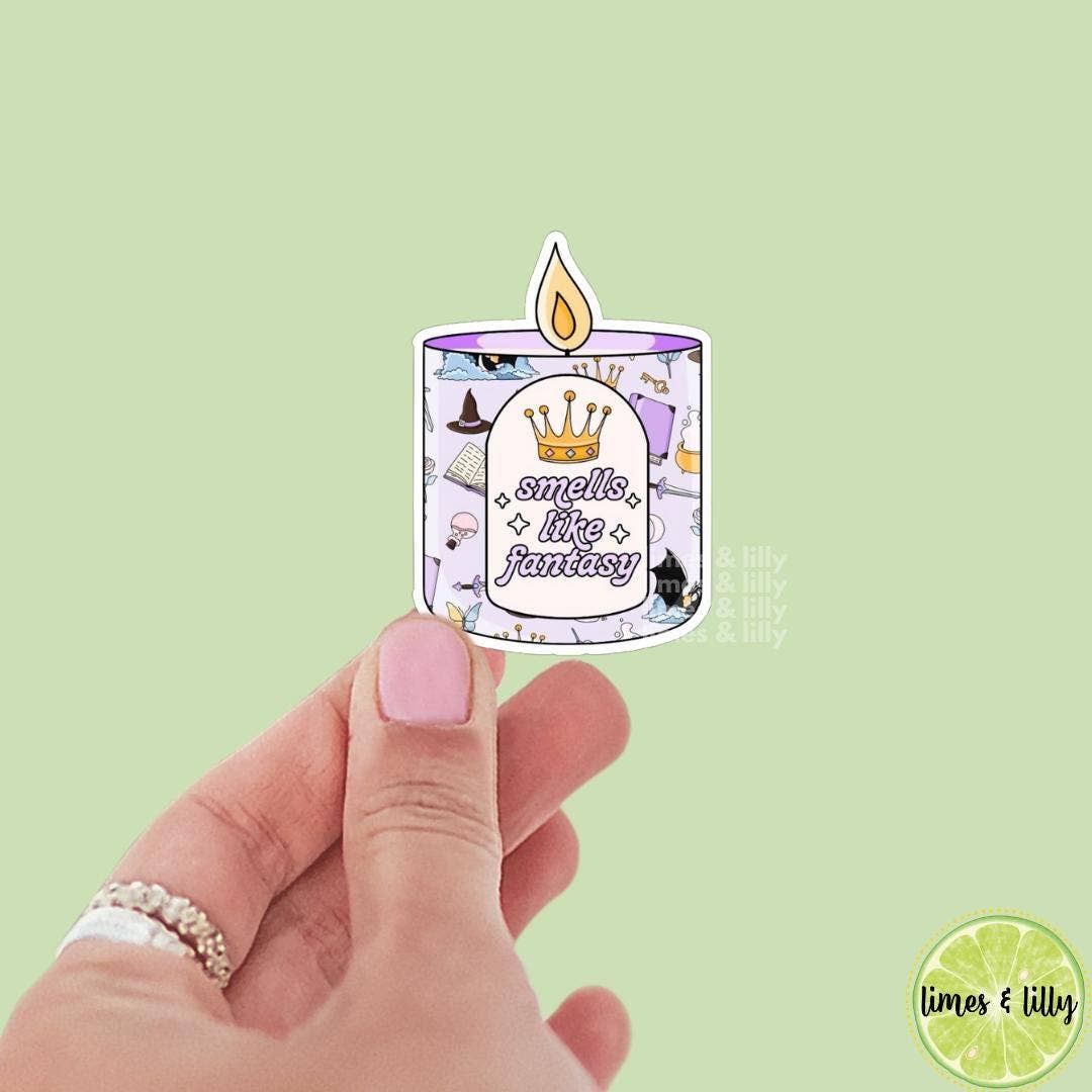 Sticker of a candle with text held by a hand against a light green background