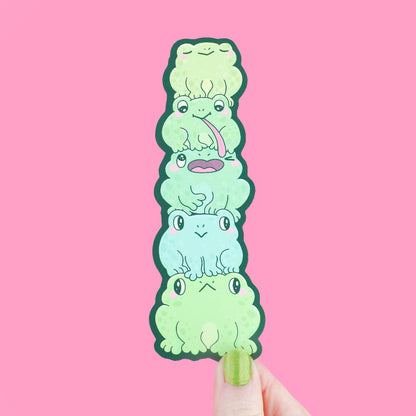 Stack of cartoon frog characters on a pink background