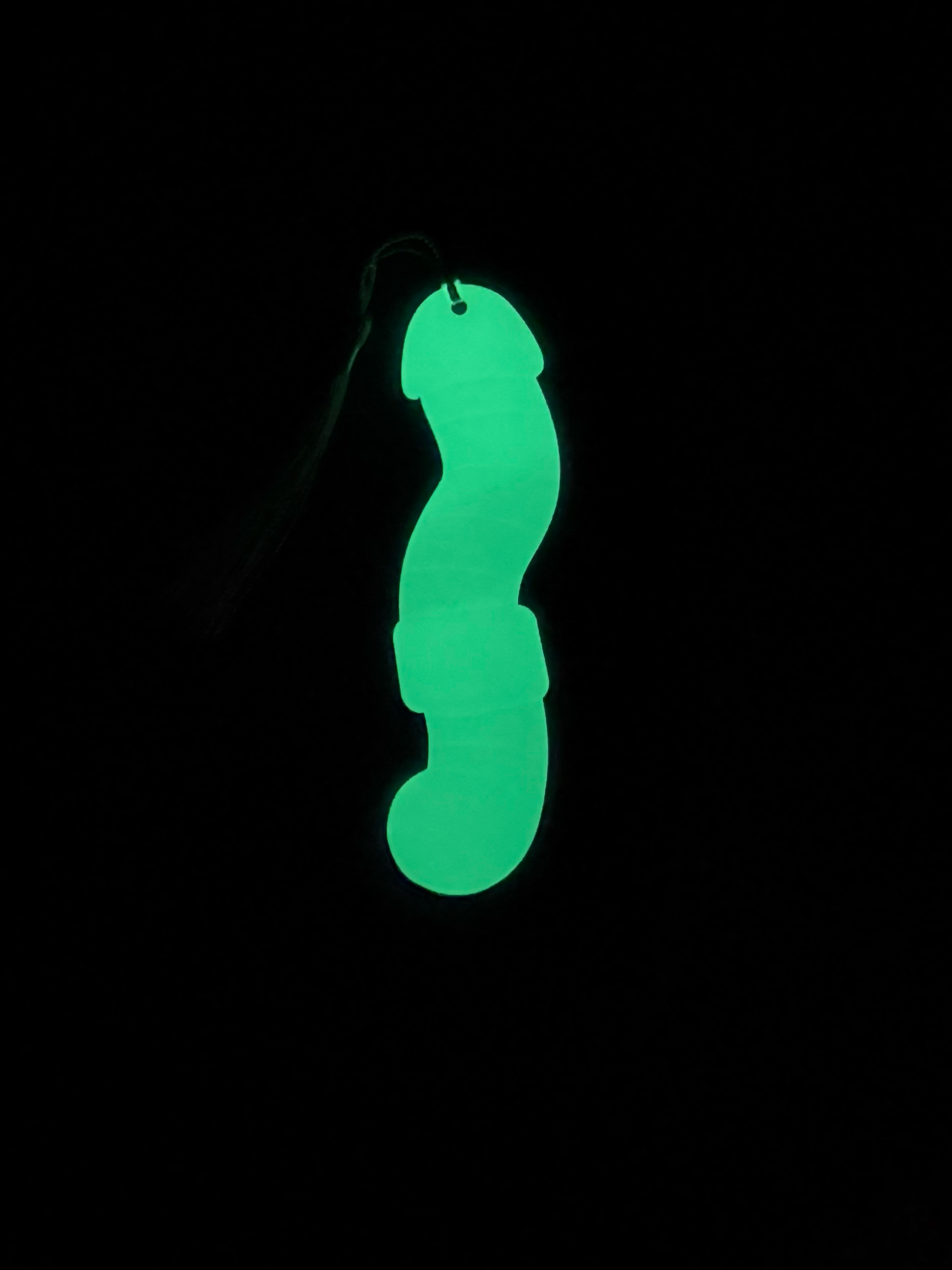 Glowing green worm-shaped object on a black background