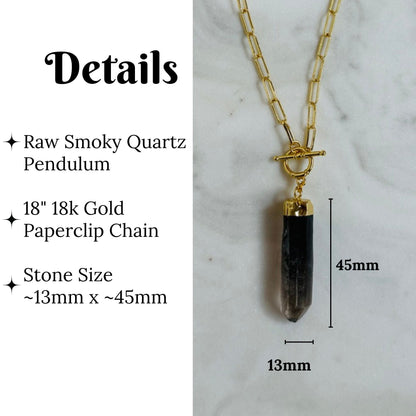 A raw smoky quartz pendant necklace on a gold paperclip chain, shown with dimension labels indicating a 45mm stone length and 13mm width, alongside text detailing the materials and measurements.