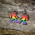 Hand-painted wooden rainbow pride Bigfoot dangle earrings featuring a colorful Sasquatch silhouette with rainbow stripes, hypoallergenic sterling silver hooks, and lightweight LGBTQ+ cryptid jewelry for pride celebrations and Bigfoot fans by Cate&
