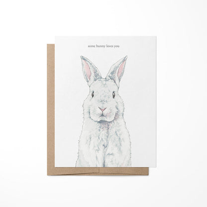 A greeting card with a watercolor painting of a bunny on the front, placed in a brown envelope.
