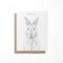 A greeting card with a watercolor painting of a bunny on the front, placed in a brown envelope.