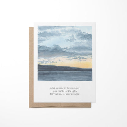 A greeting card featuring a watercolor painting of a lakeside sunset with clouds in the sky and a quote by Tecumseh.