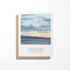 A greeting card featuring a watercolor painting of a lakeside sunset with clouds in the sky and a quote by Tecumseh.