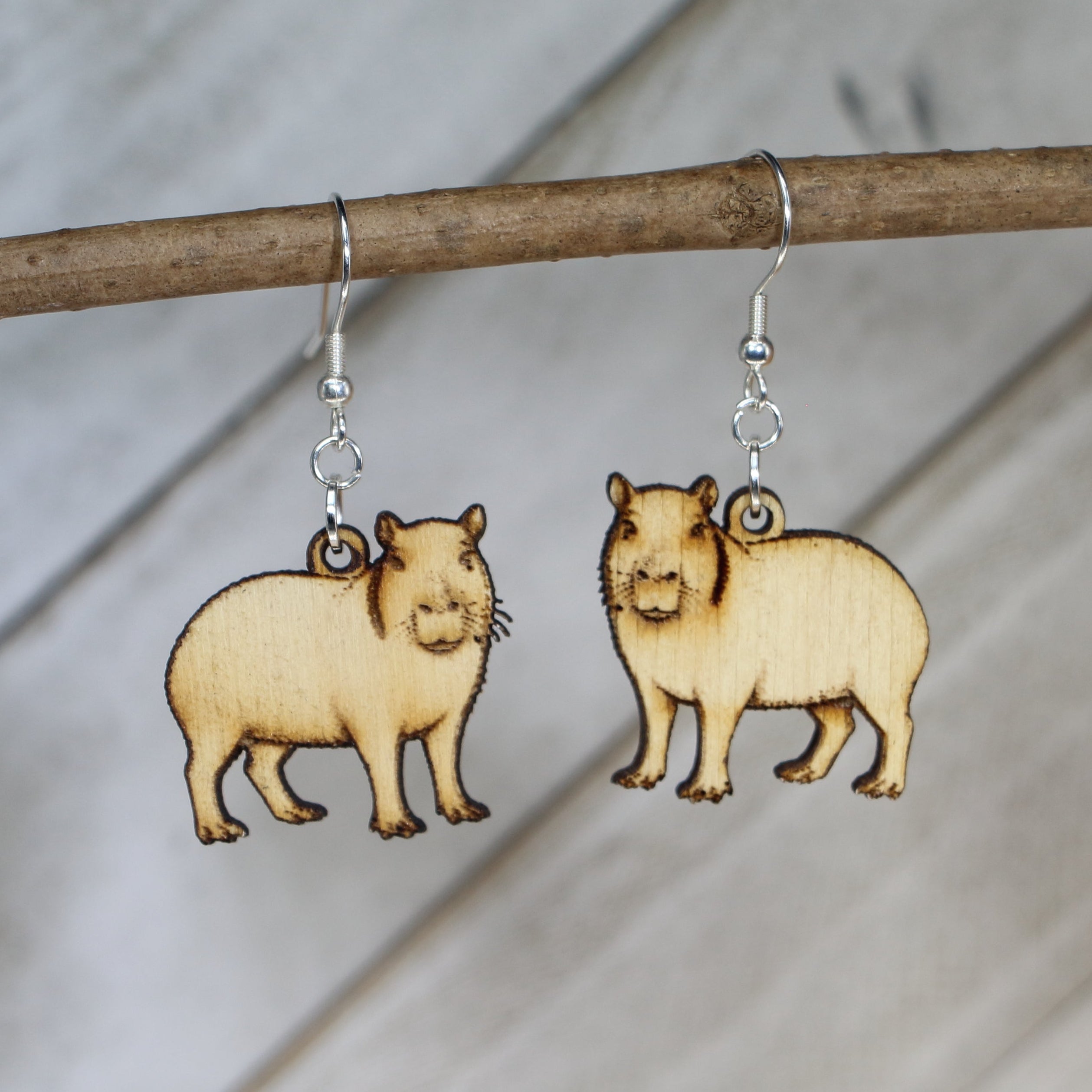 Hand-painted wooden capybara dangle earrings with cute animal design and hypoallergenic sterling silver hooks, lightweight wildlife jewelry for animal lovers and playful style by Cate’s Concepts
