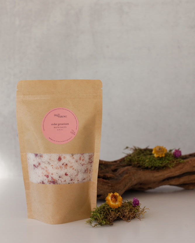 Cedar Geranium essential oil bath salts in a Kraft resealable pouch with a pink label on a neutral background - Fig &amp; Grove