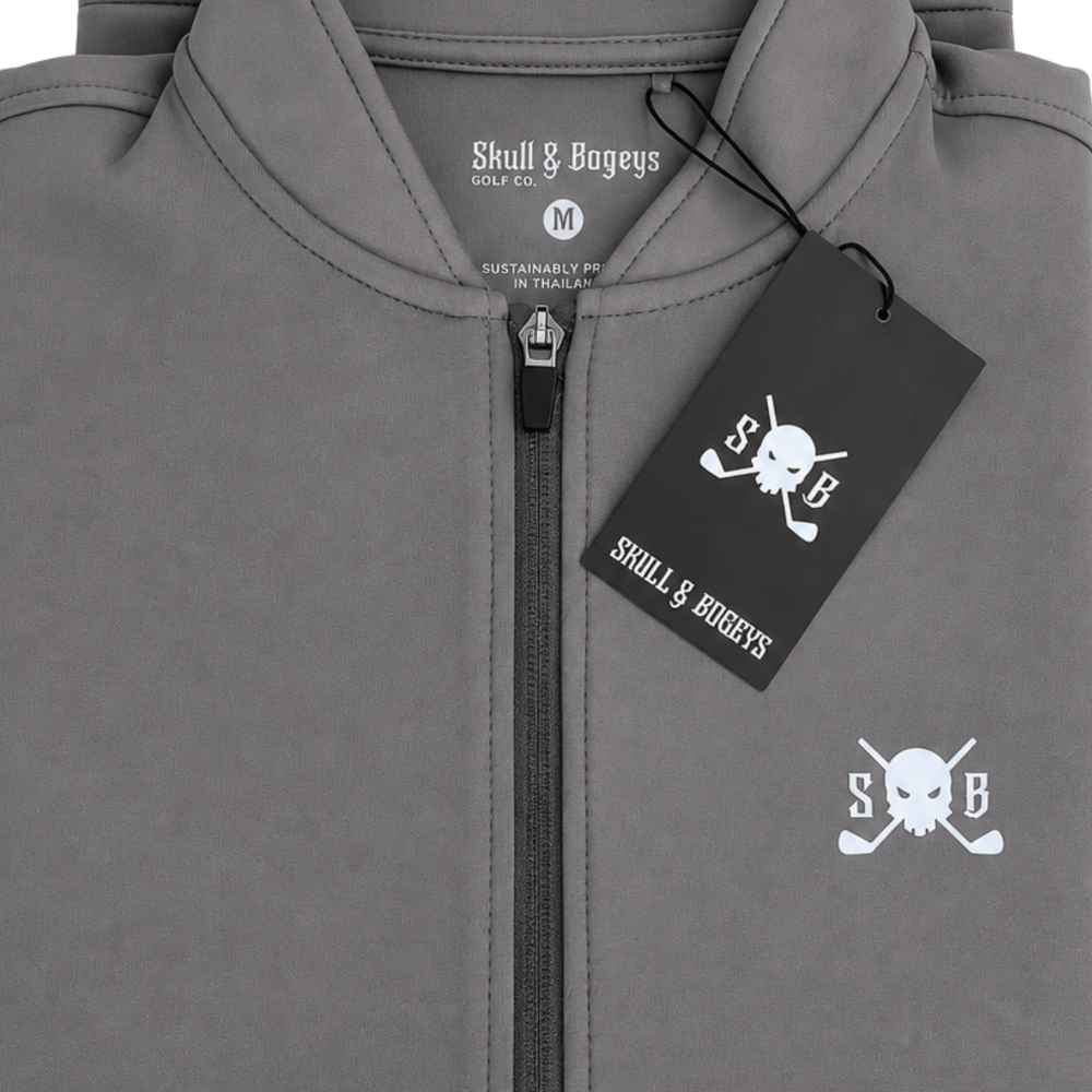 Close-up of a gray zip-up hoodie with a black hangtag and white printed Skull &amp; Bageys branding, including a skull-and-crossbones logo on the chest.