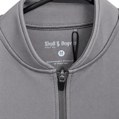 Close-up of a gray zip-up quarter-length shirt by Skull &amp; Boggs Golf Co, showing the collar, zipper, and inner neck label.